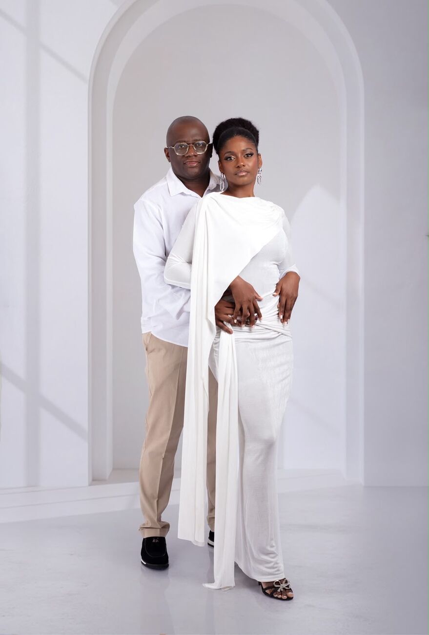 O casal de branco diante de um arco